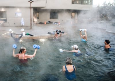 senior exercise class in the hot pool featuring weights